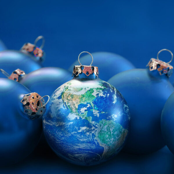 earth globe as christmas ball between blue baubles, metaphor uni